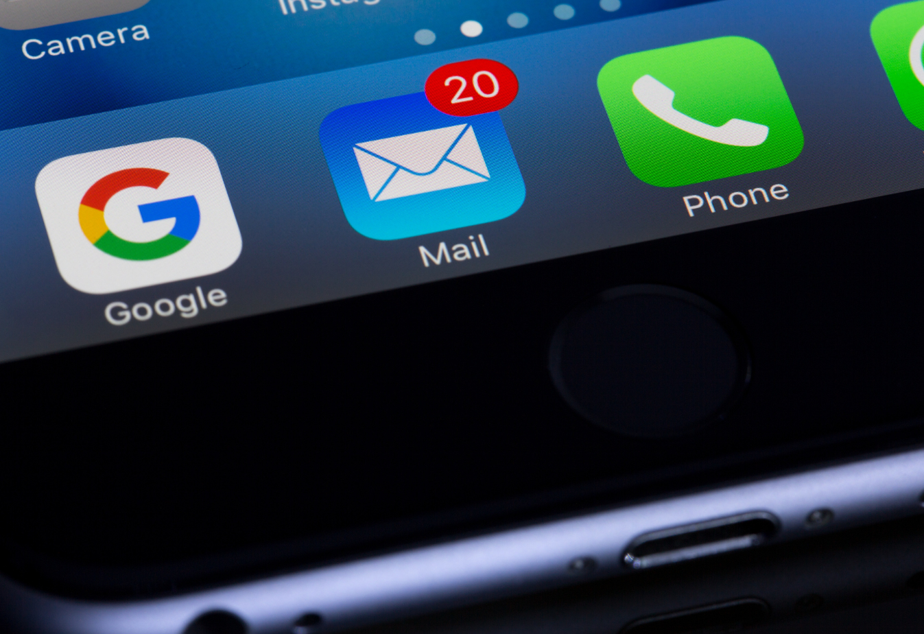 phone screen with the google app, mail app with 20 notifications and the phone app from left to right