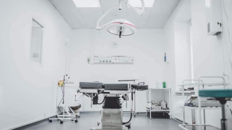 picture of an all white surgical room with a table and lamp