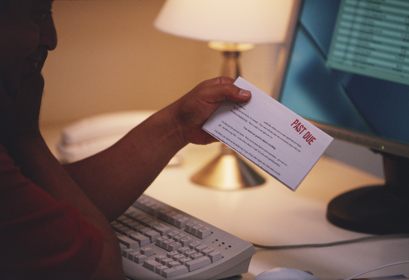 a person holding an envelope stamped with red text that says past due